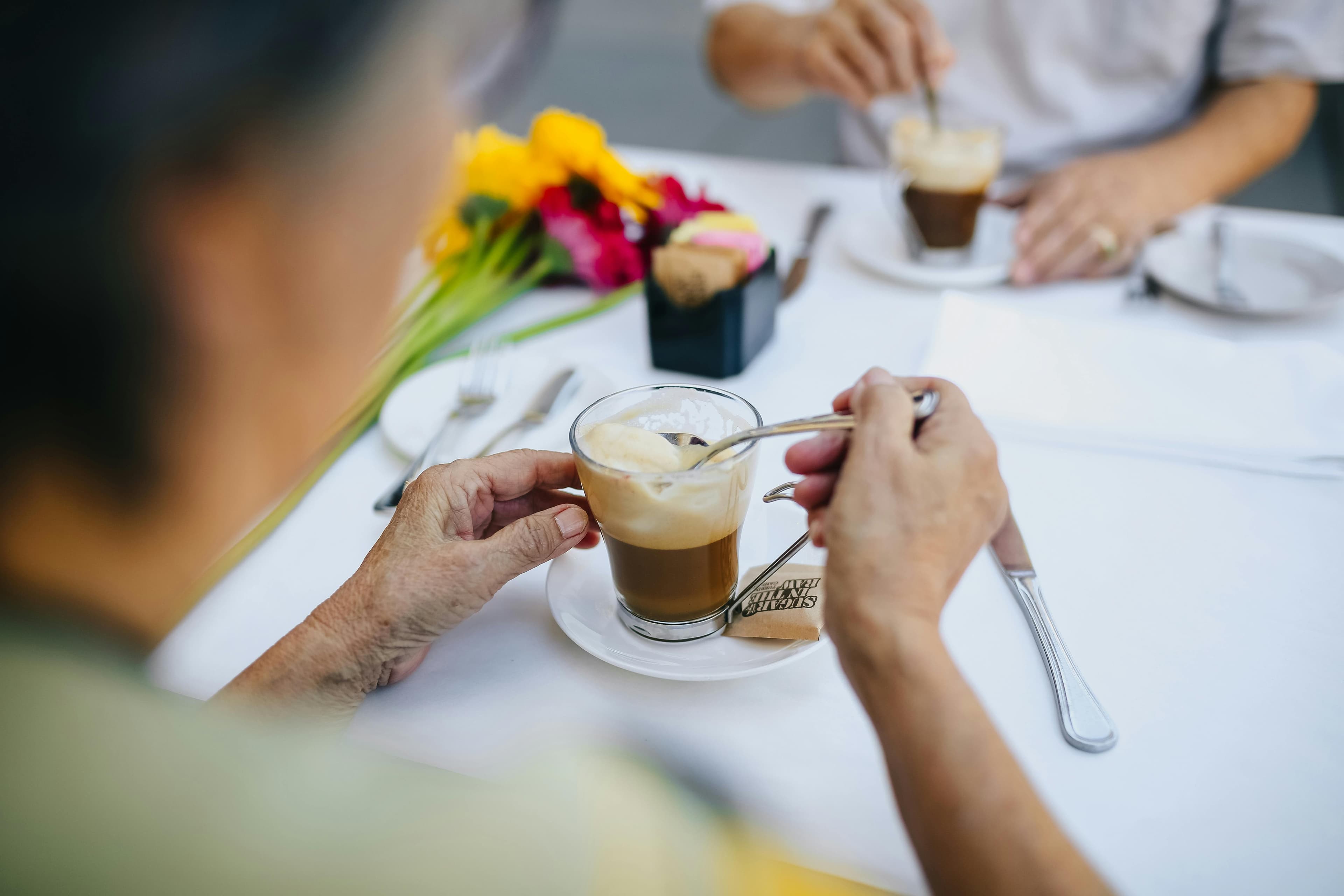 Customer receiving a coffee from staff at the counter